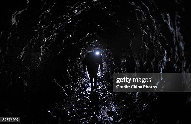 Miner suffering from silicosis digs gold in an an abandoned gold mine at the Shangshan Township on August 17, 2008 in Xiushui County of Jiangxi...