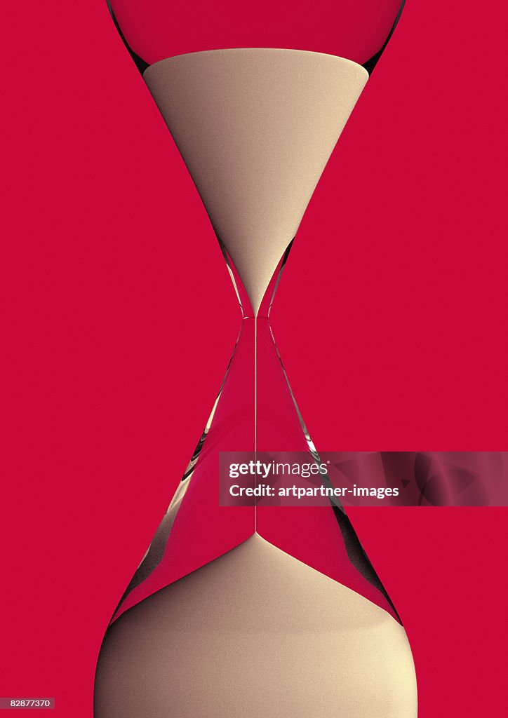 An hourglass on red background