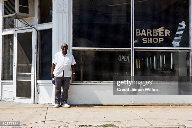 barber standing in front of his barber shop - barber stock pictures, royalty-free photos & images