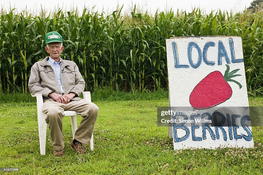 Farmer sitting in front of corn field