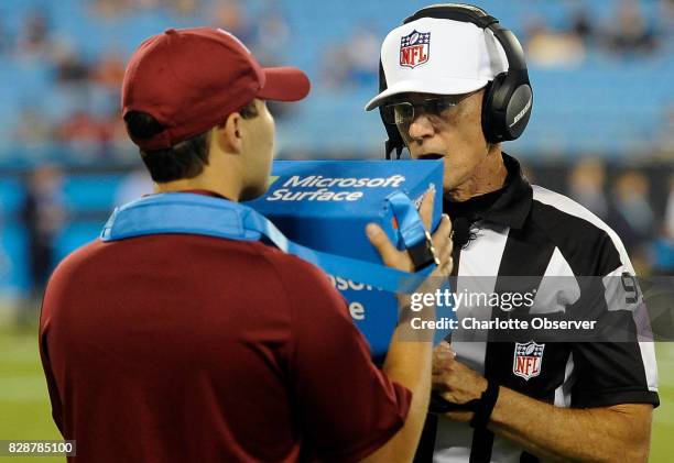 Referee Tony Corrente, right, watches a replay on the field during a break in the action as the Carolina Panthers play host to the Houston Texans at...