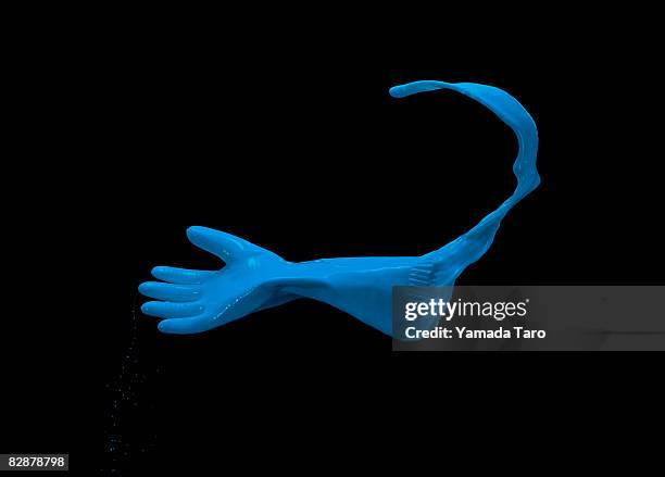 blue latex glove gloating in the air - blauer handschuh stock-fotos und bilder