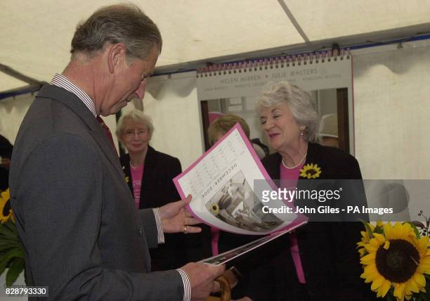 The Prince of Wales looks at a copy of the famous WI Calendar Girls new Calendar presented to him by Lynda Logan one of the WI ladies who posed for...
