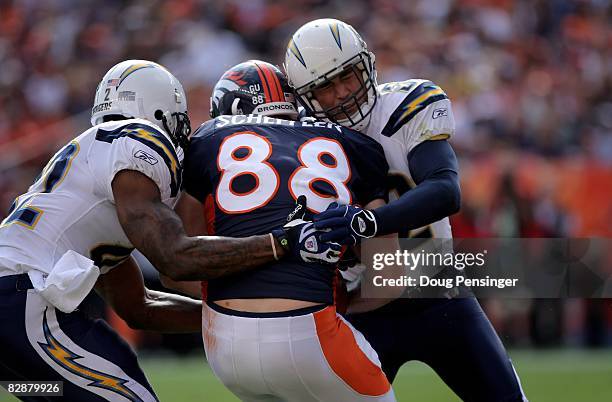 Free safety Eric Weddle of the San Diego Chargers gets help from strong safety Clinton Hart as they tackle tight end Tony Scheffler of the Denver...