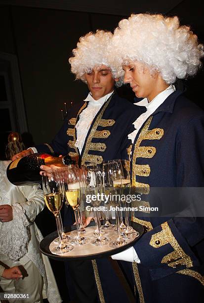 Waiters, dressed with baroque clothes, pour Moet Chandon champagne during a 'Fabulous Celebration' at Nymphenburg Castle on September 18, 2008 in...