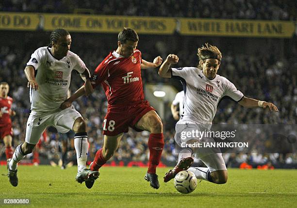 Tottenham's Jonathan Woodgate challenges Andrzej Niedzielan of Wisla Krakow also pressured by Tottenham's Cameroon player Benoit Assou-Ekotto, during...
