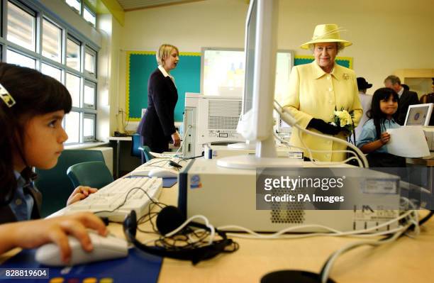 Britain's Queen Elizabeth II watches pupils using computers in the computer room at Keys Meadow Primary school, a new primary school in Enfield Lock....
