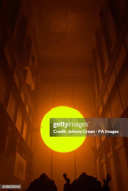 Two children observe Olafur Eliasson's installation entitled 'The Weather Project' in Turbine Hall inside the Tate Modern on the Southbank in London....