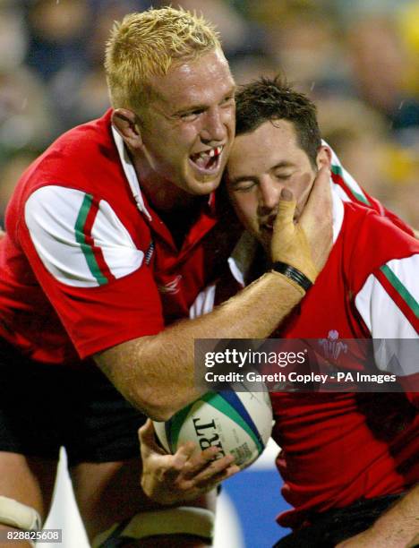 Wales's Gareth Cooper celebrates his try against Tonga with teammate Alix Popham during their World Cup pool D match at the Camberra Stadium,...