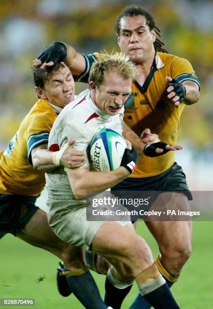 England's Matt Dawson charges throught the tackle from Australia's Matt Rodgers and George Smith during the Rugby World Cup Final at the Telstra...