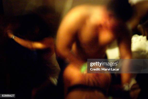 Couples switch sex partners at a "Sinsation" swingers party on October 1, 2004 in New York city. Exclusive clubs such as these screen potential...