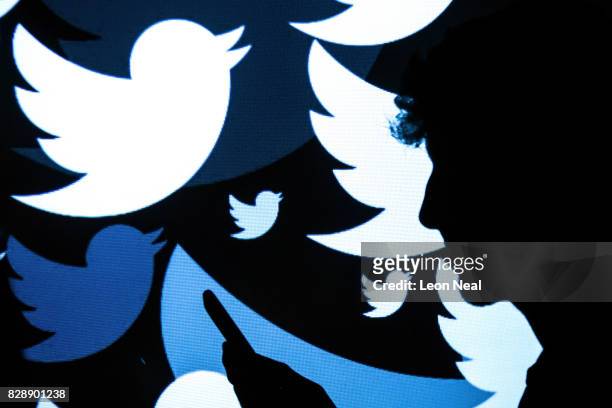 In this photo illustration, the logo for the Twitter social media network is projected onto a man on August 09, 2017 in London, England. With around...