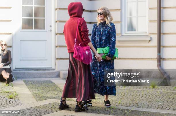 Guests wearing hoody, dress with floral print, striped skirt outside Holzweiler on August 09, 2017 in Copenhagen, Denmark.