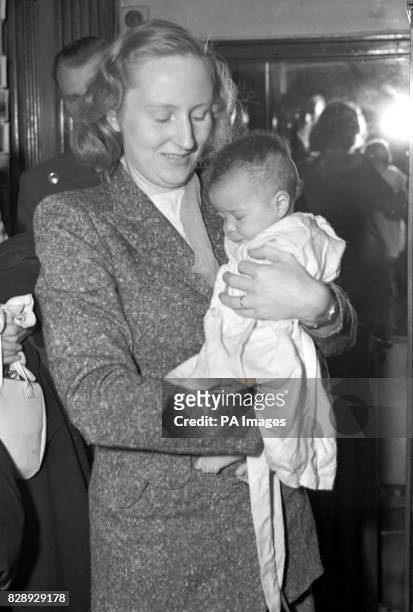 Carrying her three month old daughter Jacqueline, Mrs. Ruth Khama is pictured at the Grosvenor Court Hotel, London.