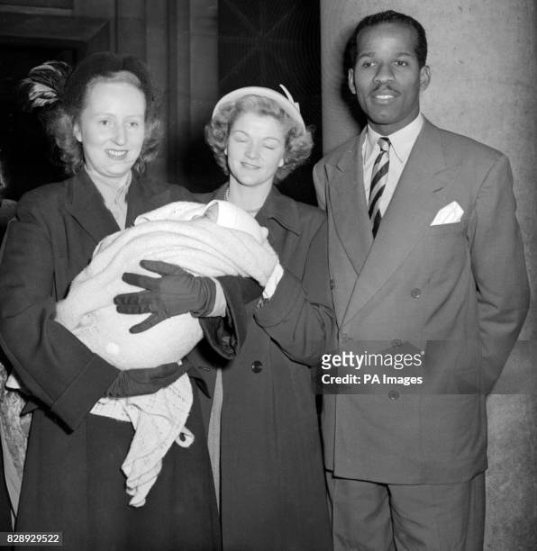 Ruth Khama, Wife of Seretse Khama, holds her God-daughter, Joan Grace Vanessa, daughter of Olympic athlete E. MacDonald Bailey after the baby had...