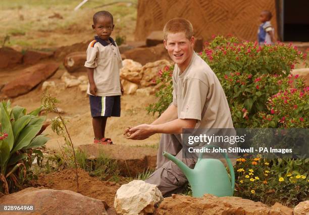 Prince Harry, the younger son of Britain's Prince Charles, with young orphan Mutsu Potsane after they planted a peach tree together at the Mants'ase...
