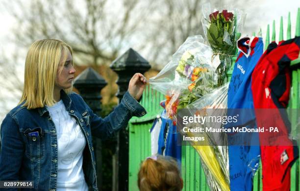 Woman looks at tributes lefts on a fence in Glasgow, where 15-year-old schoolboy Kriss Donald was snatched by a group of five men near, his home in...