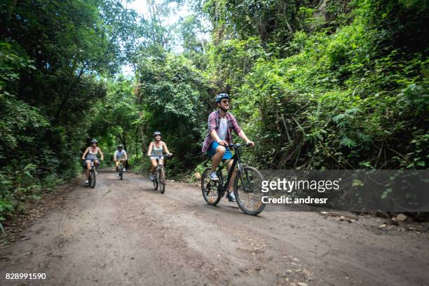 group of people biking outdoors and looking very happy - eco tourism stock pictures, royalty-free photos & images