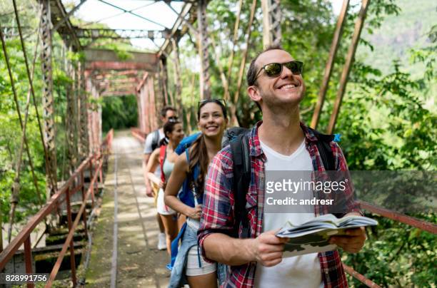 hombre feliz senderismo con un grupo - turismo ecológico fotografías e imágenes de stock