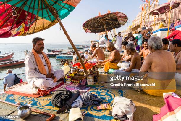 Priest, Brahmin, is working with pilgrims at the holy river Ganges at Dashashwamedh Ghat, Main Ghat, in the suburb Godowlia.