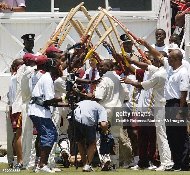 West Indian captain Brian Lara leaves the field to an archway of bats held by his team-mates after breaking the World Record previously held by...