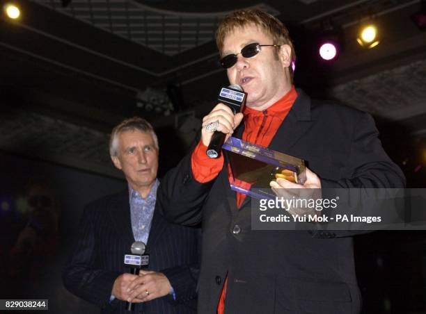 Sir Elton John presents the Gold Award to Radio 2 DJ Johnnie Walker, on stage during the Sony Radio Academy Awards 2004, held at Grosvenor House...