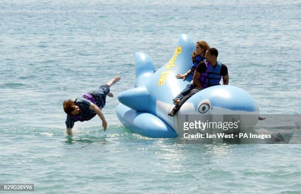 Actor Jack Black leaps into the waters as Will Smith and Angelina Jolie look on as they ride an inflatable shark during a photocall for the new...