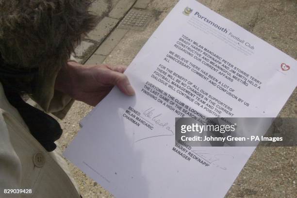 Journalist holds a copy of a statement issued by Portsmouth Football Club regarding the future of manager Harry Redknapp and his assistant Jim Smith...