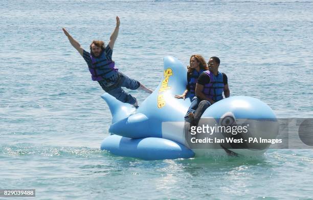Actor Jack Black leaps into the waters as Will Smith and Angelina Jolie look on as they ride an inflatable shark during a photocall for the new...