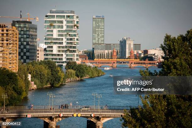 Picture taken on August 9, 2017 shows a view of the river Spree with the Oberbaumbruecke bridge in Berlin. / AFP PHOTO / AXEL SCHMIDT