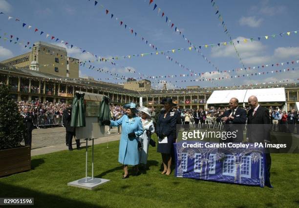 Britain's Queen Elizabeth II unveils a plaque at Piece Hall in Halifax, Yorkshire, a former market place for local weavers which is now a thriving...