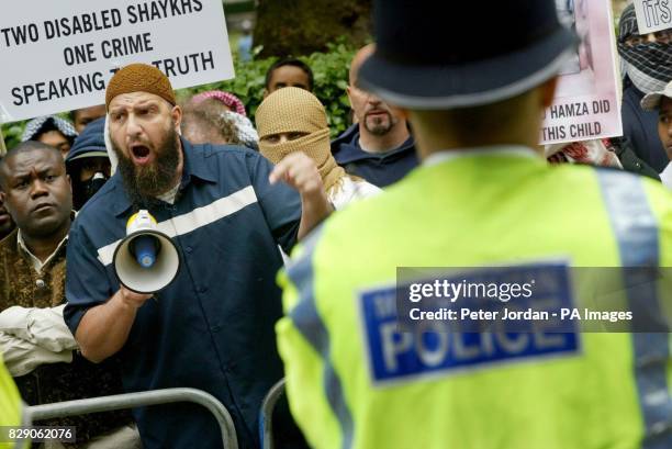 Abdul Abdulla, a leader from Finsbury Park mosque, speaks on a megaphone outside the American Embassy in London as demonstrators gather. Protesters...