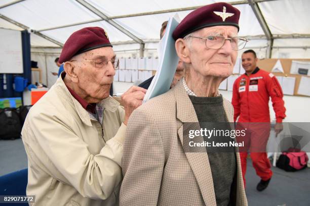 Former paratrooper Ted Pieri signs his waiver form on the back of fellow veteran Fred Glover ahead of their skydive at the Old Sarum airfield on...