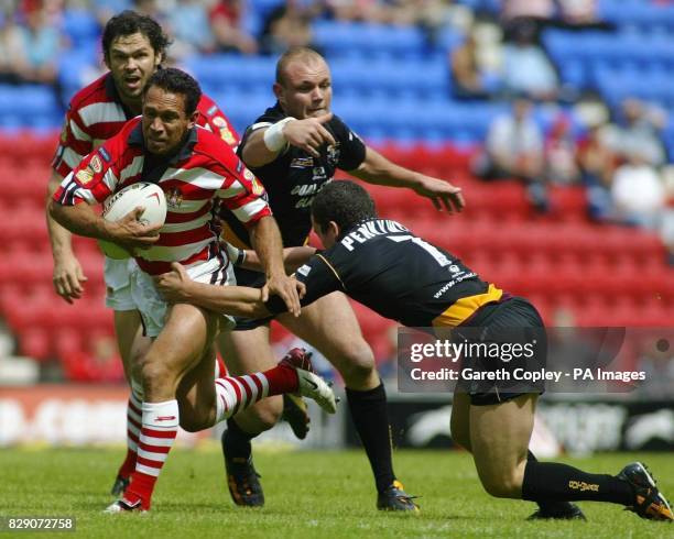 Wigan's Adrian Lam tries to escape Huddersfield's Ben Roarty and Sean Penkywicz during the Tetley's Super League match at the JJB Stadium.