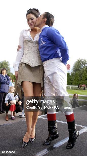 Model Catherine McQueen is kissed by jockey Frankie Dettori on the catwalk during the Girls Night Out fashion show, held at Kempton Park racecourse,...