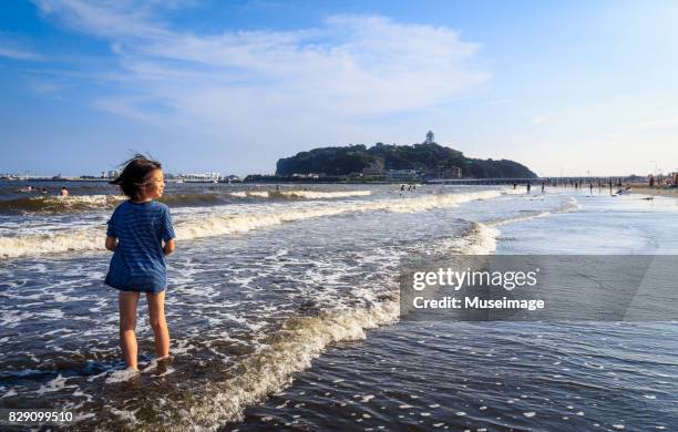 a boy standing in the koshigoe beach, fujisawa-kanagawa, japan - enoshima island stock pictures, royalty-free photos & images