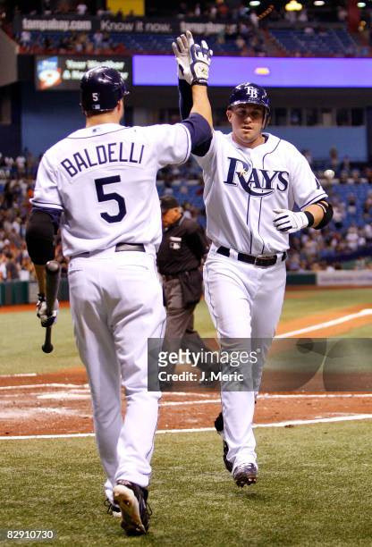 Infielder Evan Longoria of the Tampa Bay Rays is congratulated by Rocco Baldelli after his home run against the Minnesota Twins during the game on...