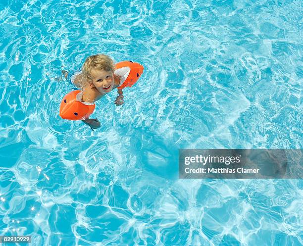 little boy happy learning how to swim - brazaletes acuáticos fotografías e imágenes de stock