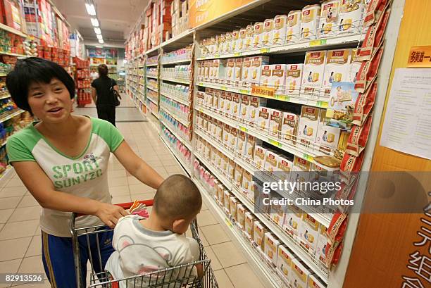 Mother with her baby buys milk powder products of foreign brands at a Wal-Mart store on September 19, 2008 in Changchun of Jilin Province, China....