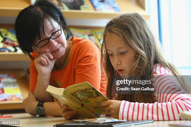 Fourth-grade student reads a book with her teacher in the elementary school at the John F. Kennedy Schule dual-language public school on September...