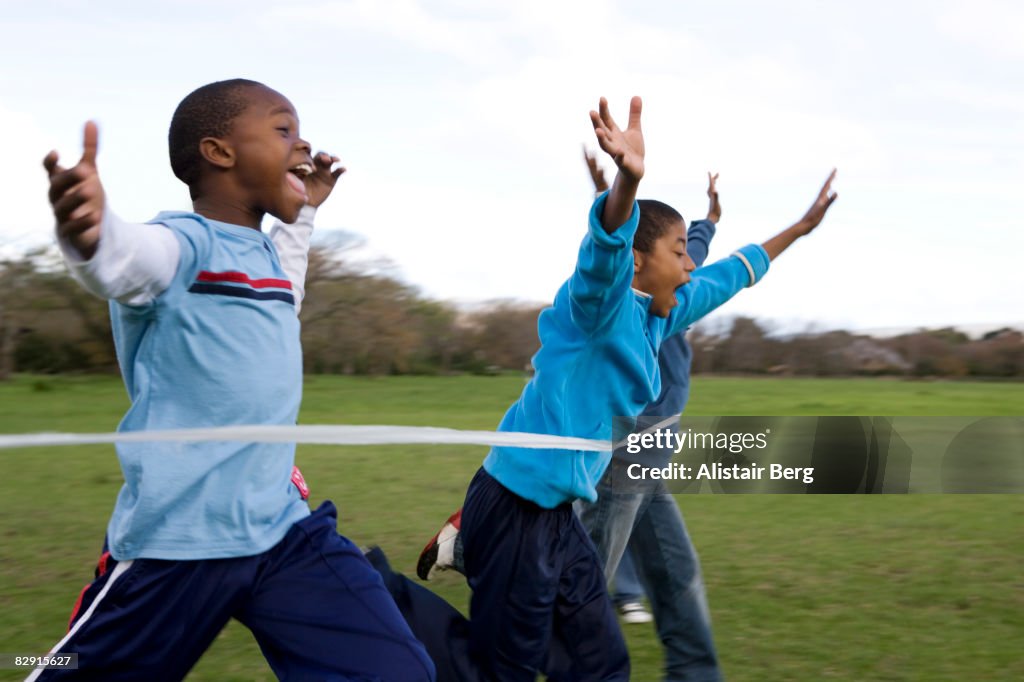 Boys running through finishing line