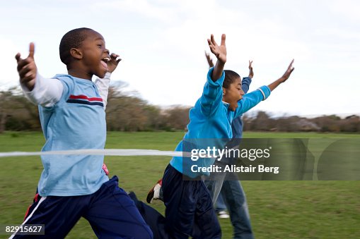 Boys running through finishing line Boys running through finishing line
