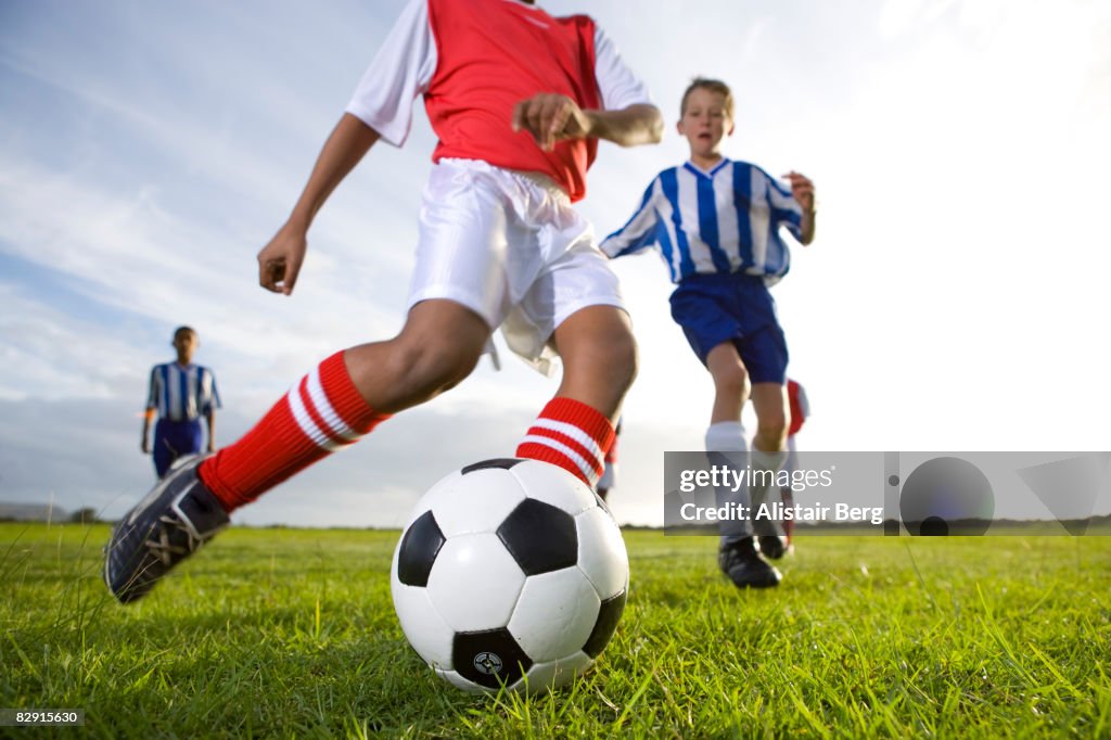 Close up of boy kicking football