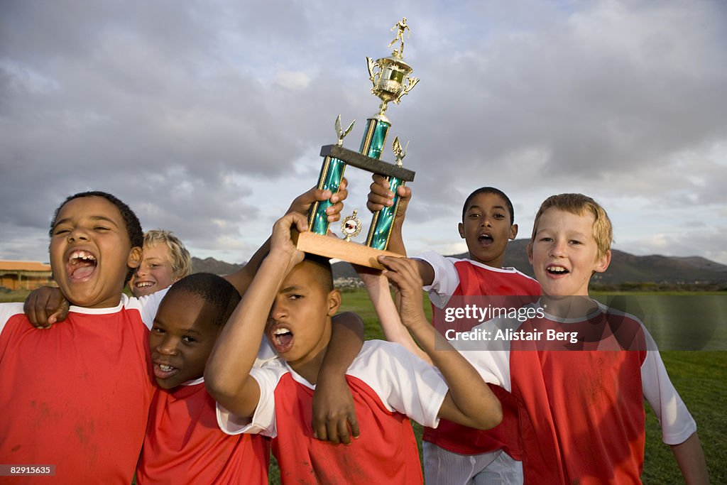 Football team celebrating with trophy