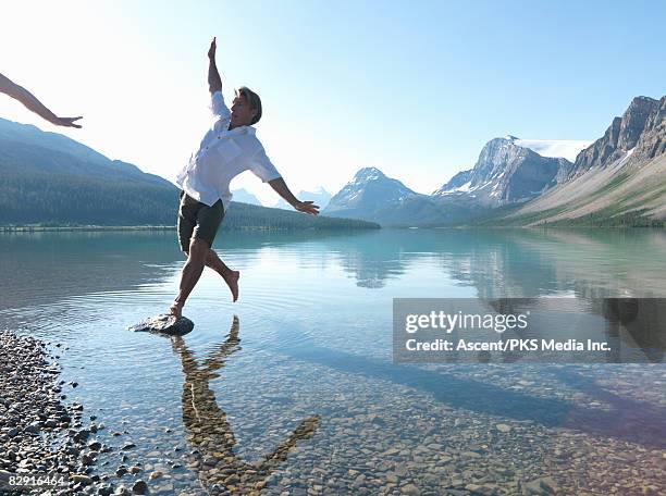 woman's arm pushing man into bow lake - 転ぶ ストックフォトと画像