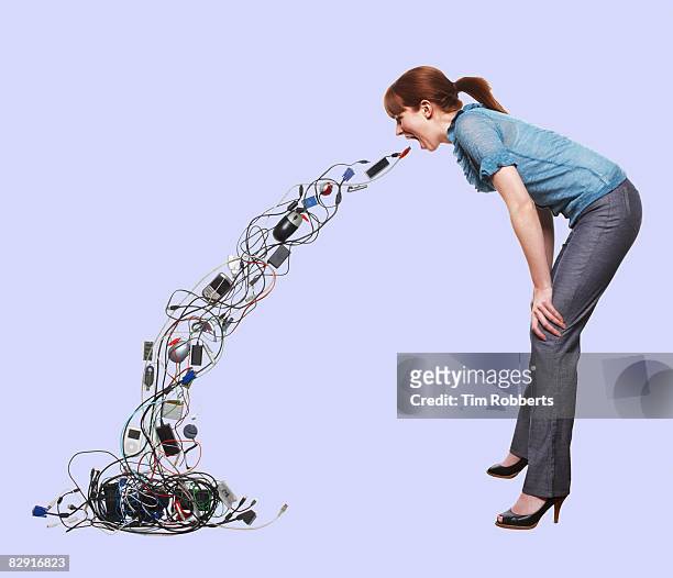 young woman throwing up electrical items - electrical overload stockfoto's en -beelden
