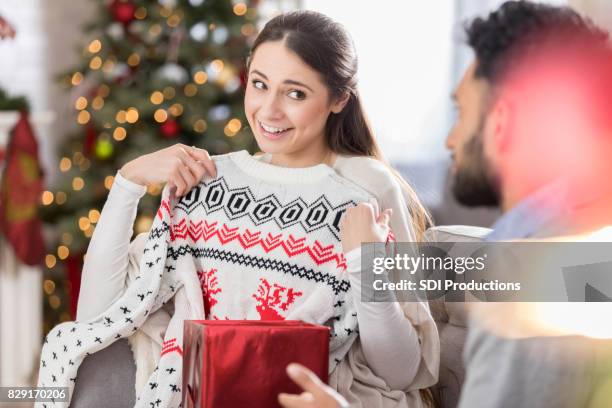 mulher abre o presente contendo camisola de natal - ugly christmas sweater party - fotografias e filmes do acervo