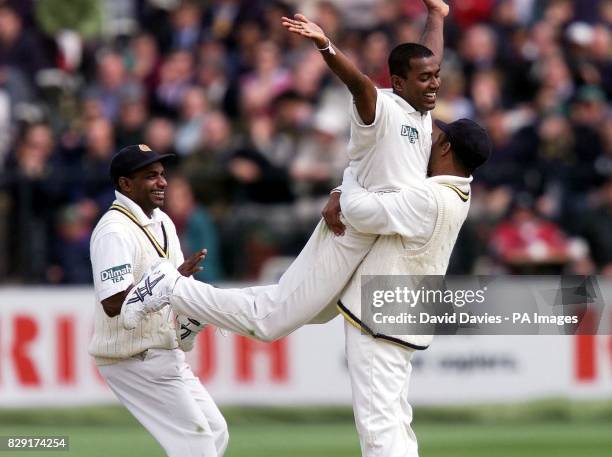 Sri Lankan bowler Ruchira Perera is embraced by team-mate Hashan Tillakaratne, with captain Sanath Jayasuriya running in to celebrate, after trapping...