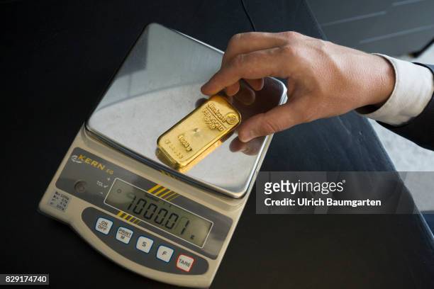 Fake gold reinforced in circulation. Different test methods for authenticity, here the test of the weight of a 1000g gold bar with an electronic...