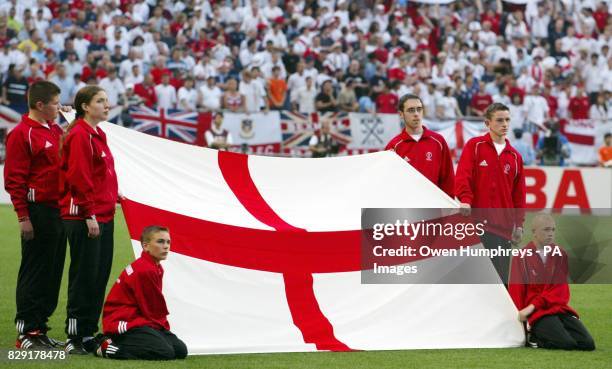 England flag bearers carry the St Georges flag onto the pitch ahead of the World Cup, Group F, first round match between England and Sweden at...